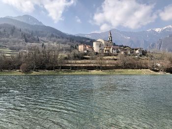 Scenic view of lake by buildings against sky