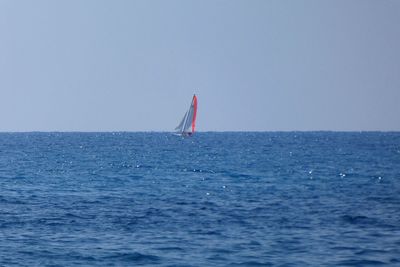 Sailboat in sea against clear sky