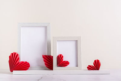 Two blank photo frames decorated with diy paper hearts. home decor.