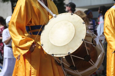 Midsection of man playing drum during tradition festival