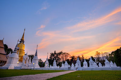 Panoramic view of trees and buildings against sky during sunset