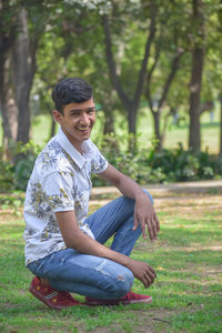 Portrait of young man sitting on field