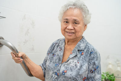 Portrait of a smiling woman against wall