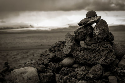 Close-up of stack of rock at beach against sky