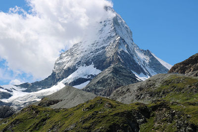 Low angle view of snowcapped mountains against sky