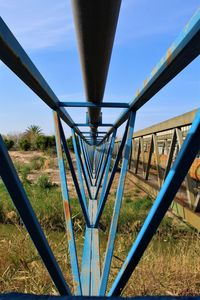 Close-up of metallic structure on field against clear sky