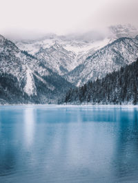 Scenic view of lake and snowcapped mountains against sky