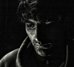 Close-up portrait of man against black background