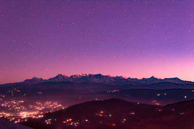 Silhouette mountains against sky at night