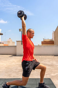 Side view of man exercising on terrace