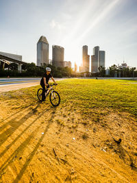 Rear view of man riding bicycles on field