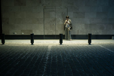 Full length of woman standing on wall