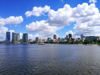 Sea by buildings against sky in city