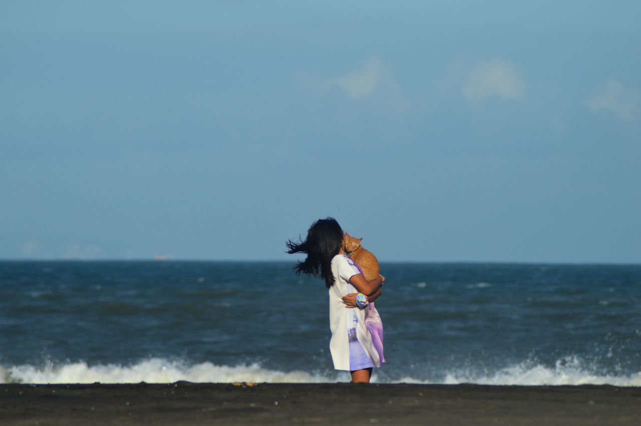 sea, water, sky, horizon over water, horizon, beach, land, ocean, one person, nature, women, vacation, full length, coast, day, shore, leisure activity, child, beauty in nature, standing, blue, female, childhood, motion, adult, wave, rear view, body of water, clothing, casual clothing, holiday, outdoors, scenics - nature, lifestyles, trip, person, copy space, tranquility, emotion, sand, dress