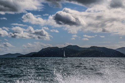 Scenic view of sea and mountains against sky