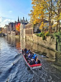 Men in boat on river against sky