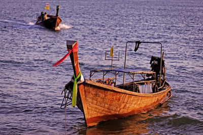 Fishing boat moored in sea against sky