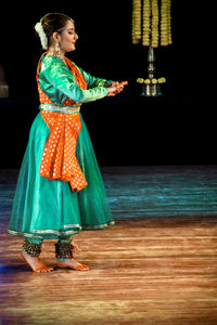 Side view of a smiling young woman standing outdoors