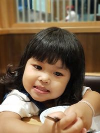 Close-up portrait of cute girl at home