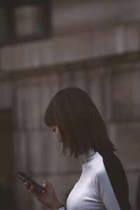 Side view of woman using mobile phone