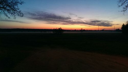 Scenic view of silhouette field against sky during sunset