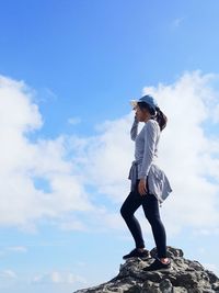 Low angle view of young man standing against sky