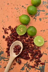 Cool green limes hot red dried chili peppers on tabletop 