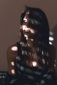 Sunlight falling on young woman in darkroom