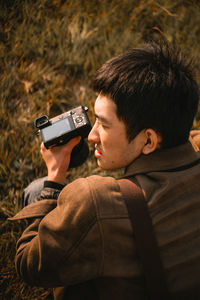 Young man photographing with mobile phone
