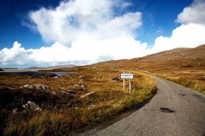 Road by mountains against sky