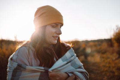 Young woman standing against sky