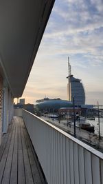 Bridge over river by buildings against sky