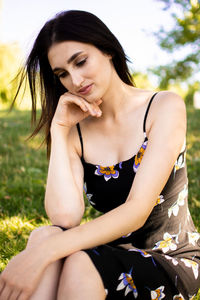 Portrait of young woman sitting on grass