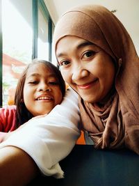 Portrait of happy mother and daughter at home