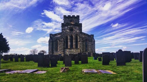 Historic building in cemetery against sky