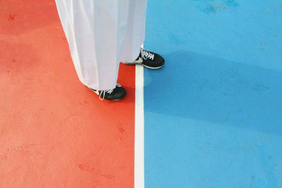 Low section of person standing by swimming pool