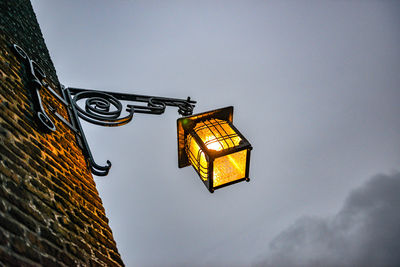 Low angle view of illuminated street light against building