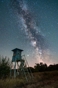 Windmill on field against sky at night