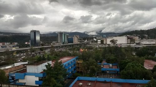 View of cityscape against cloudy sky