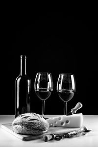 Wine glasses on table against black background