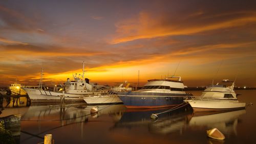 Boats in harbor at sunset