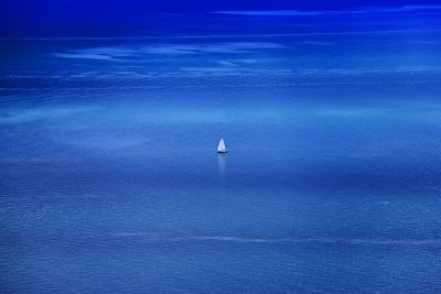 Sailboats in sea against blue sky