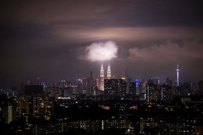 Panoramic view of illuminated buildings against cloudy sky