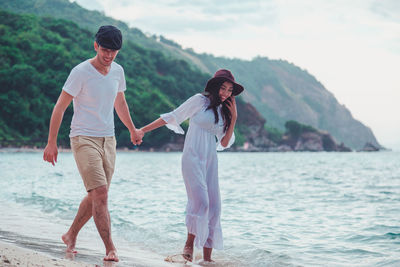 Rear view of friends standing on sea shore