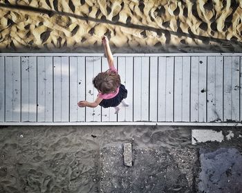 Full length of girl standing against wall