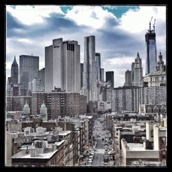 Modern cityscape against cloudy sky