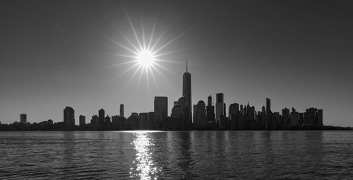 Hudson river against one world trade center amidst tower during sunny day