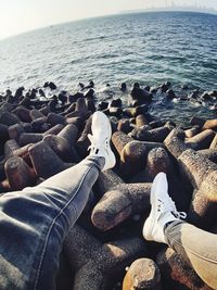 Low section of rocks by sea against sky