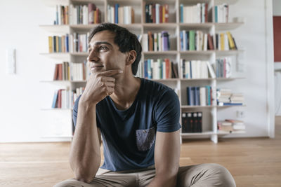 Smiling young man at home looking sideways