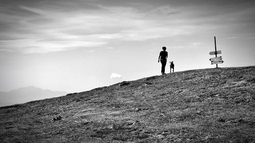 Men standing on mountain against sky